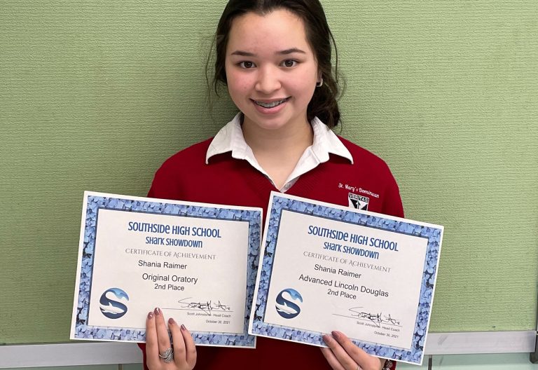 Dominican Junior Shania Raimer holding her 2nd Place Speech and Debate Certificates
