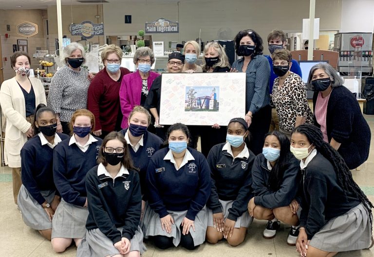 Students, faculty, and administration gather with Mrs. Joy for a group photo.