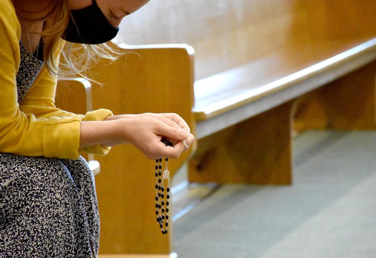 Campus Minister Rebecca Wallace ’15 prays before the start of a Rosary Walk.